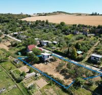 A view of the area with cottages in picturesque Myjava, surrounded by fields and gardens.