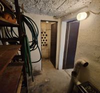 A storage space in a cabin with hoses and metal shelves.