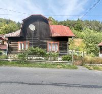 A family house in the village of Ochodnica on Ochodnica Street, with a wooden facade and a red roof.