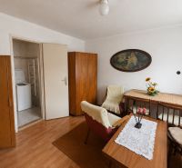 Interior of a family house with wooden decor, a dining table, and open doors to the laundry room.
