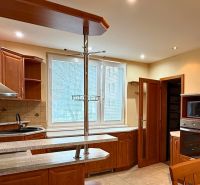 A kitchen in a 3-room apartment with wooden cabinets and tiled flooring.