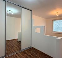 Interior of a 3-room apartment with a wooden decor floor and a built-in wardrobe.