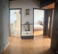 Interior of a 3-room apartment with a wooden decor floor and entrance to the living room and bedroom.