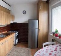 A kitchen in a 3-room apartment with a kitchen unit, a gas stove, and a floor with a wooden decor.