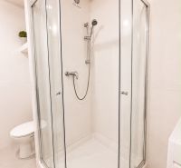Shower corner with toilet and washing machine in a 2-room apartment.