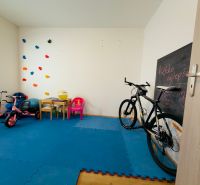 A children's room with toys, a bicycle, and a drawing board in a family house.