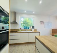 A kitchen with a wood-patterned floor in a family house, bright and spacious.