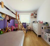 Children's room in a family house with a bunk bed, toys, and a wooden decor floor.