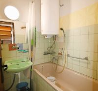 Bathroom in a 3-room apartment with a bathtub, sink, and boiler.