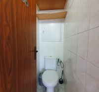 Bathroom in a 3-room apartment with tiles and storage space above the toilet.