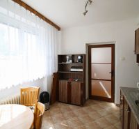 A kitchen with a table and chairs in a 3-room apartment, floor with wooden decor.