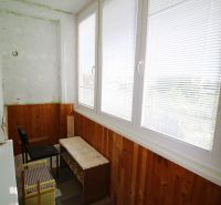 Glazed loggia in a 3-room apartment with wooden paneling and tiles.