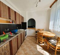 A kitchen with patterned cabinets, a dining table, and a large window, a 3-room apartment.
