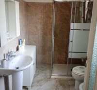 Bathroom in a holiday apartment with a sink, shower, and toilet.