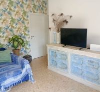 Recreational apartment with a television, a colorful wall, and a comfortable armchair.