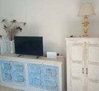 Wooden furniture with blue details and a television in a holiday apartment.