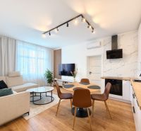 Living room in a 3-room apartment with a wooden decor floor and a light-colored sofa.