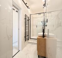 A bathroom with a bathtub, a sink, and glossy white walls in a 3-room apartment.
