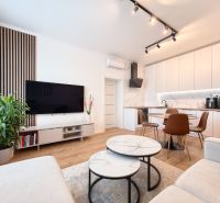 Living room in a three-room apartment with a wooden decor floor and modern furnishings.