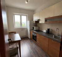 A kitchen in a 4-room apartment with a wooden decor floor and a modern kitchen unit.