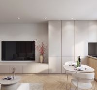 Living room in a two-room apartment, with a TV, dining table, and wooden decor flooring.