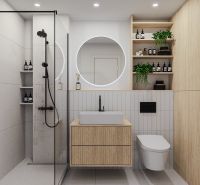 Bathroom with a shower, wooden cabinets, and a round mirror in a 2-room apartment.