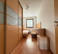 A bedroom with a wardrobe and a wooden decor floor in a 4-room apartment.