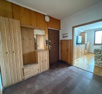 Entrance hall in a 4-room apartment with wooden cabinets and a floor with a wooden decor.