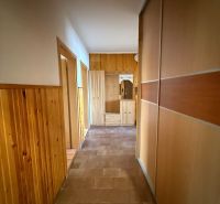 A hallway in a 4-room apartment with wood paneling and built-in wardrobes.