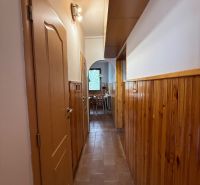 A narrow corridor with light wood paneling in a 4-room apartment.