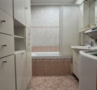 A bathroom with a bathtub and built-in cabinets in a 4-room apartment.