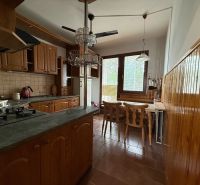 A kitchen with built-in appliances and wooden cabinets in a 4-room apartment.