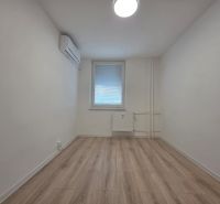 A room with air conditioning and a wooden decor floor in a 3-room apartment.