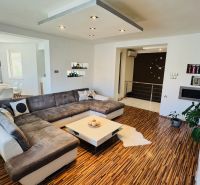 Living room in a family house with a large sofa set and a wooden decor floor.