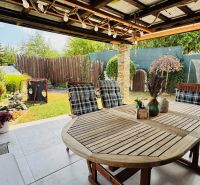 The terrace of a family house in Radobica with seating, greenery, and a view of the garden.