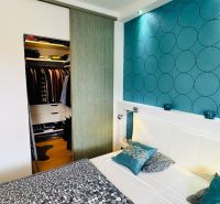 Bedroom in a family house with storage space and wallpaper with circles.