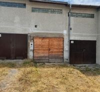 Garages on Môťová Street in Zvolen with concrete facades and wooden gates.