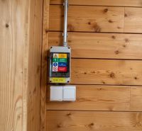Wooden panel on the wall with a light switch in the garage.