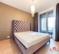 Bedroom in a 2-room apartment with a bed, chandelier, wooden decor flooring.