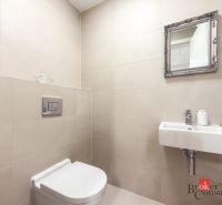 A bathroom in a 2-room apartment with a sink and a mirror on the wall.