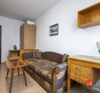 A room in a 4-room apartment with a retro sofa, a table, and a desk.