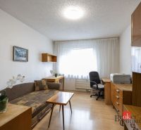 Living room with a sofa, office chair, and wooden-patterned flooring in a 4-room apartment.