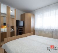 Bedroom in a 4-room apartment with a television and a wardrobe in a wooden decor.