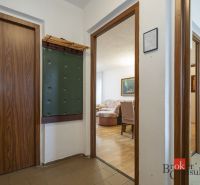 A hallway leading to the living room with a wooden decor floor in a 4-room apartment.