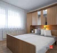 Bedroom with a bed, built-in wardrobe, and floor with wood decor in a 4-room apartment.