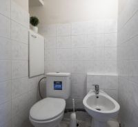A bathroom with white tiles and sanitary ware in a 4-room apartment.