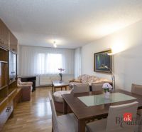 Living room in a 4-room apartment with a wooden decor floor and dining for four people.