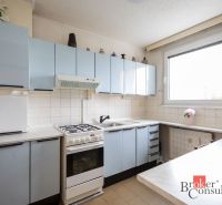 A kitchen in a 4-room apartment with light blue cabinets and a white tiled wall.