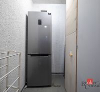 A combined refrigerator in a narrow room in a 4-room apartment with textured walls.