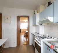 A kitchen in a 4-room apartment with a gas stove and blue cabinets.